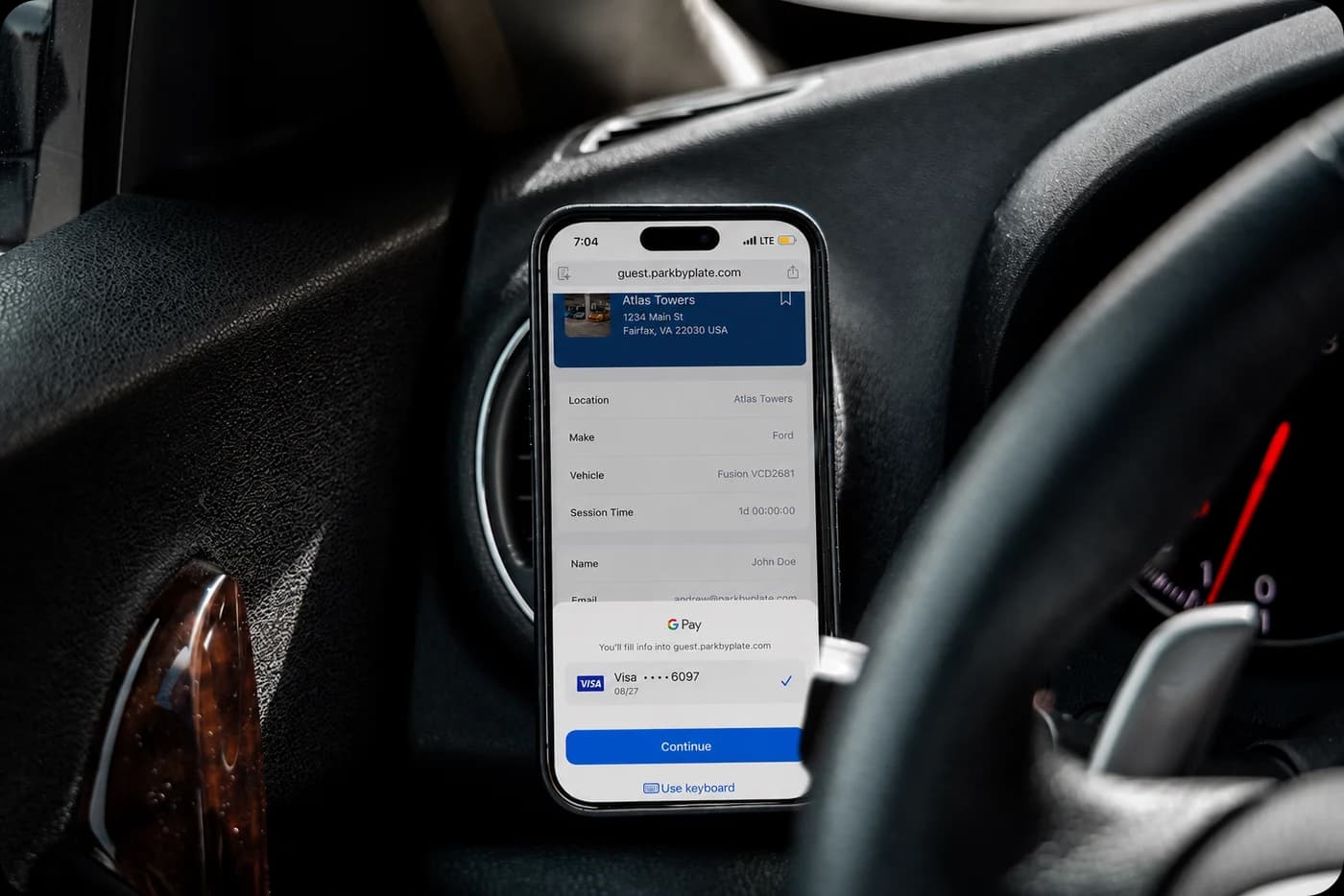 A guest registering from the driver's seat: guest.parkbyplate.com open in the phone's browser showing the community, their vehicle and session length, with a saved card ready to confirm.
