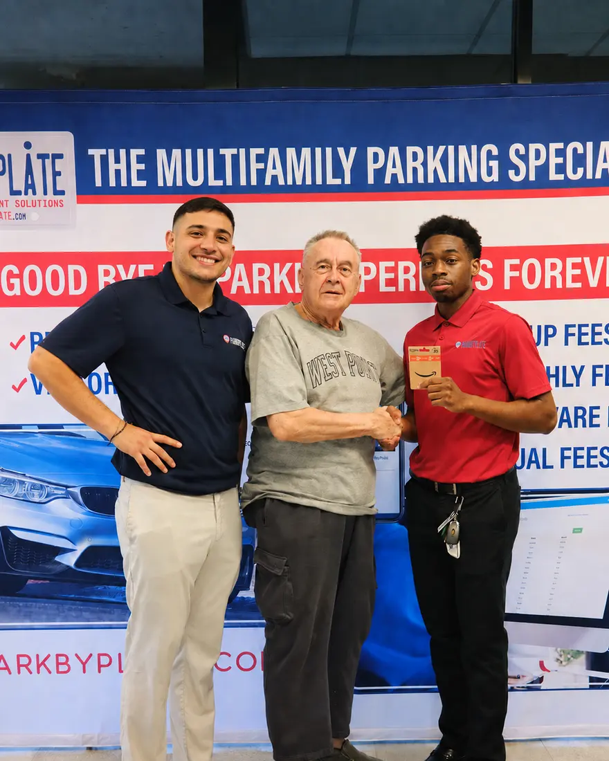 Team members with a resident at a community parking event.
